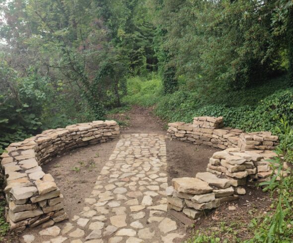 Création d'un mur pierres sèches Charly Mur en pierres sèches encadrant une allée dallée en sous-bois